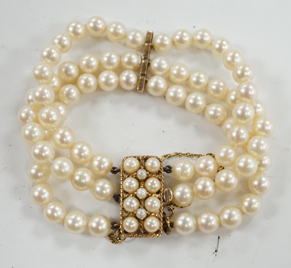 A triple strand cultured pearl necklace, with 9ct and cultured pearl clasp and spacer, 18cm. Condition - fair